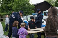 policjanci pomagają ubrać sie dzieciom w sprzęt policyjny
