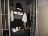 Policjant z zatrzymanym mężczyzna w korytarzu policyjnego aresztu