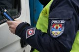 Ręka policjanta wydziału ruchu drogowego z urządzeniem do pomiaru zawartości alkoholu w wydychanym powietrzu