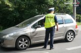 Zdjęcie kolorowe: policjant zabrzańskiej drogówki podczas kontroli trzeźwości kierującego samochodem osobowym